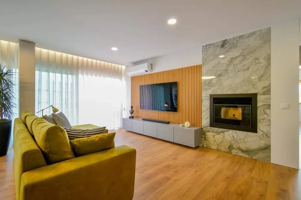 Sala com lareira e painel em madeira · PROJota Remodelações